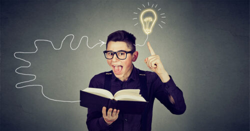 Amazed man in glasses reading book comes up with an idea